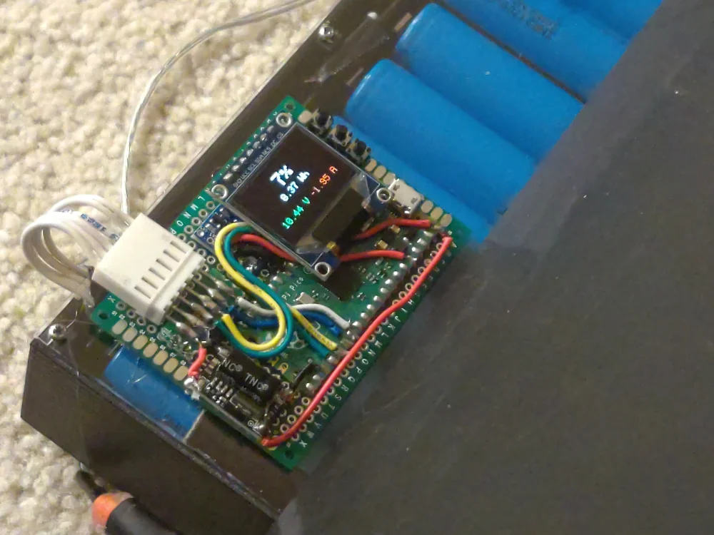 BattMITM running on a pi pico on a piece of protoboard with a small oled, voltage regulator, and molex connector, mounted to the custom-built battery on the back of my ThinkPad T420